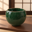 Cuenco verde oscuro con esmalte craquelado, ambientado en sala de té japonesa.