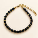Pulsera de Ónix Negro con Detalles Dorados