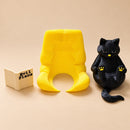 Figura decorativa de gato negro lector en sillón amarillo